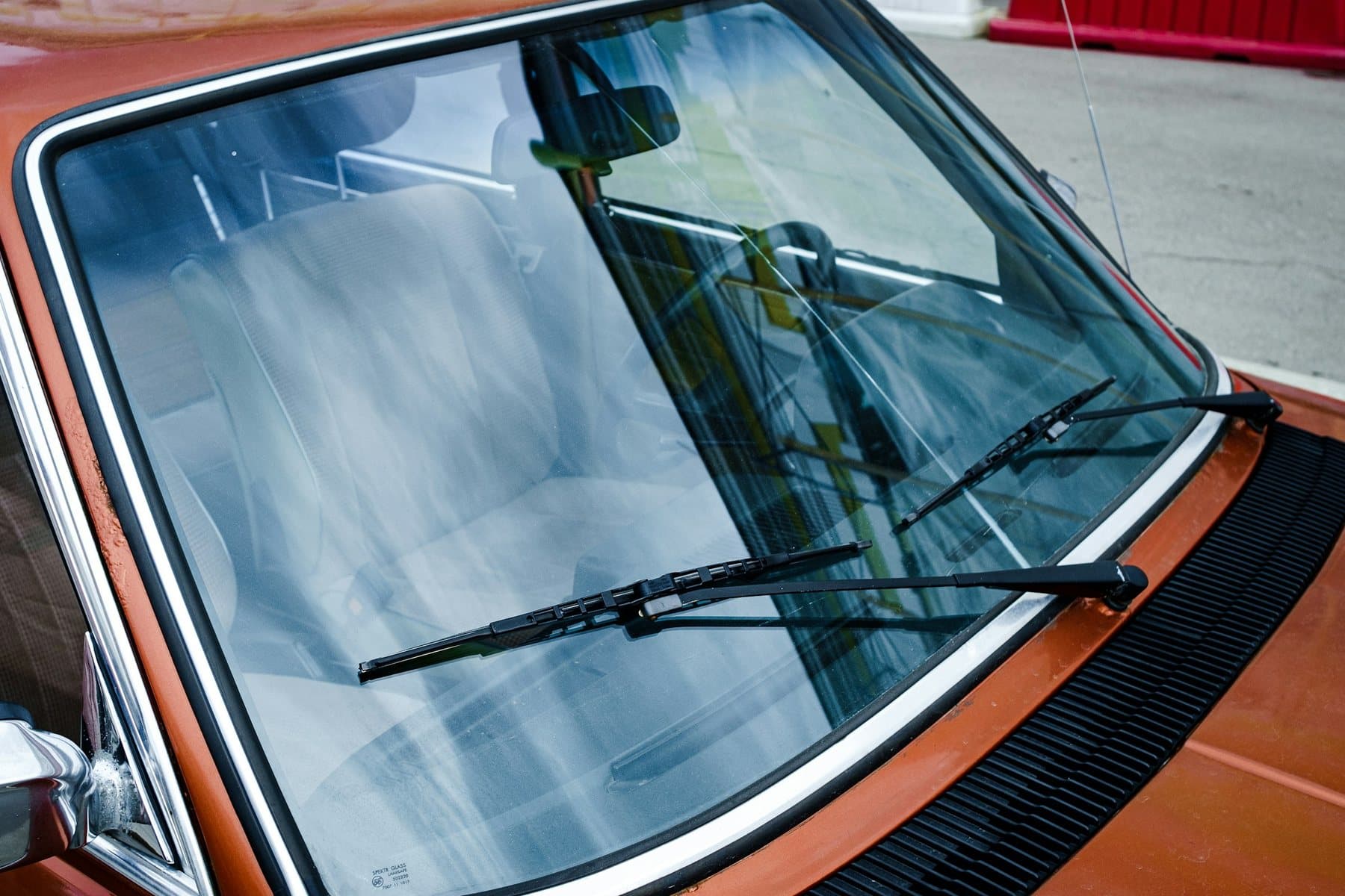 Clean vehicle windshield with wipers raised before glass service